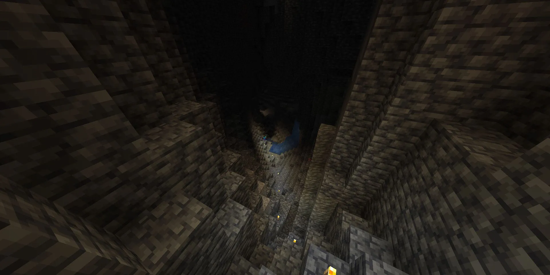 Steve cầm đuốc khám phá một hang động sâu và tối trong Minecraft