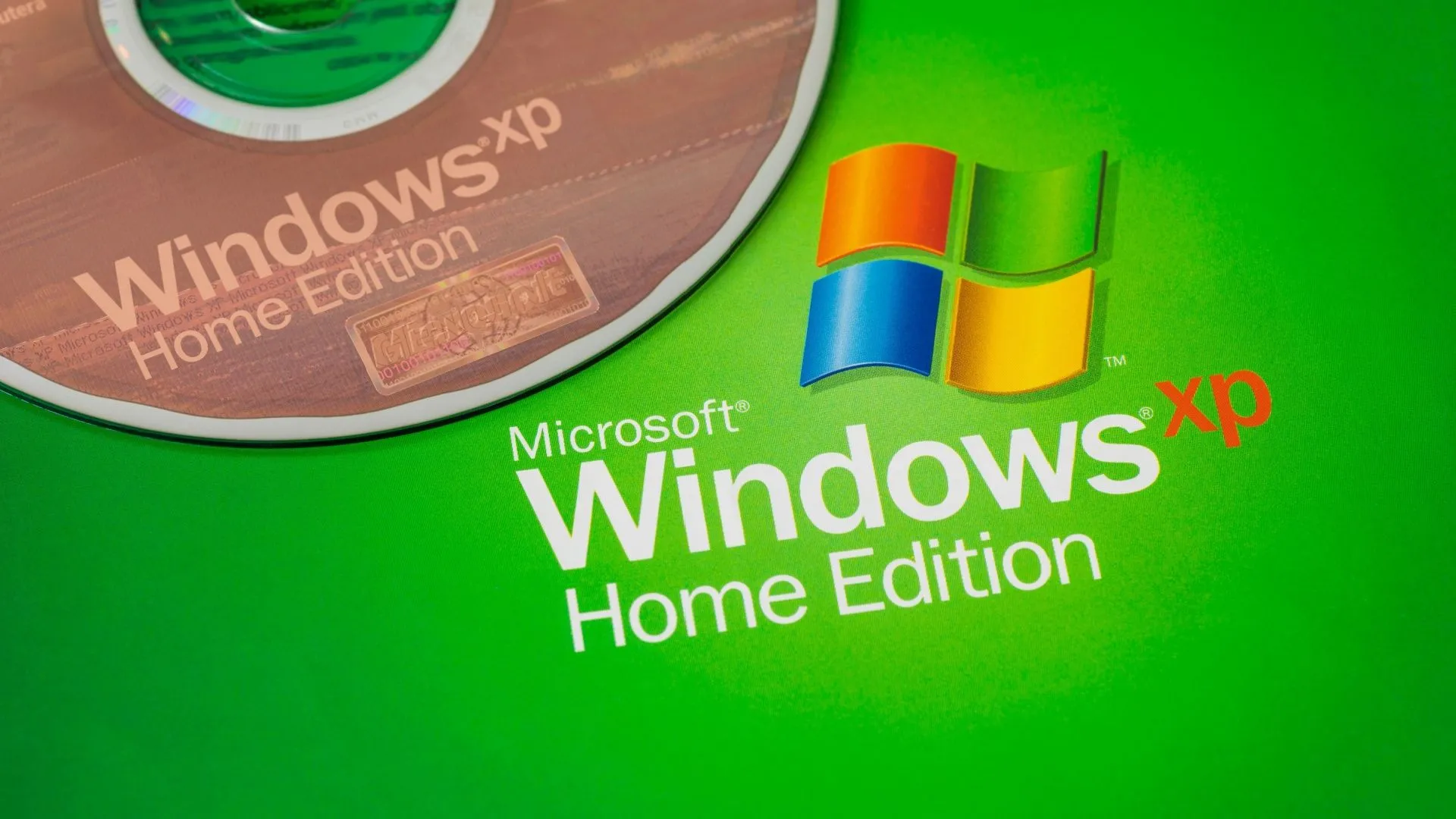 Đĩa cài Windows XP cạnh logo Windows XP, nhắc nhớ thời vàng son của hệ điều hành này.