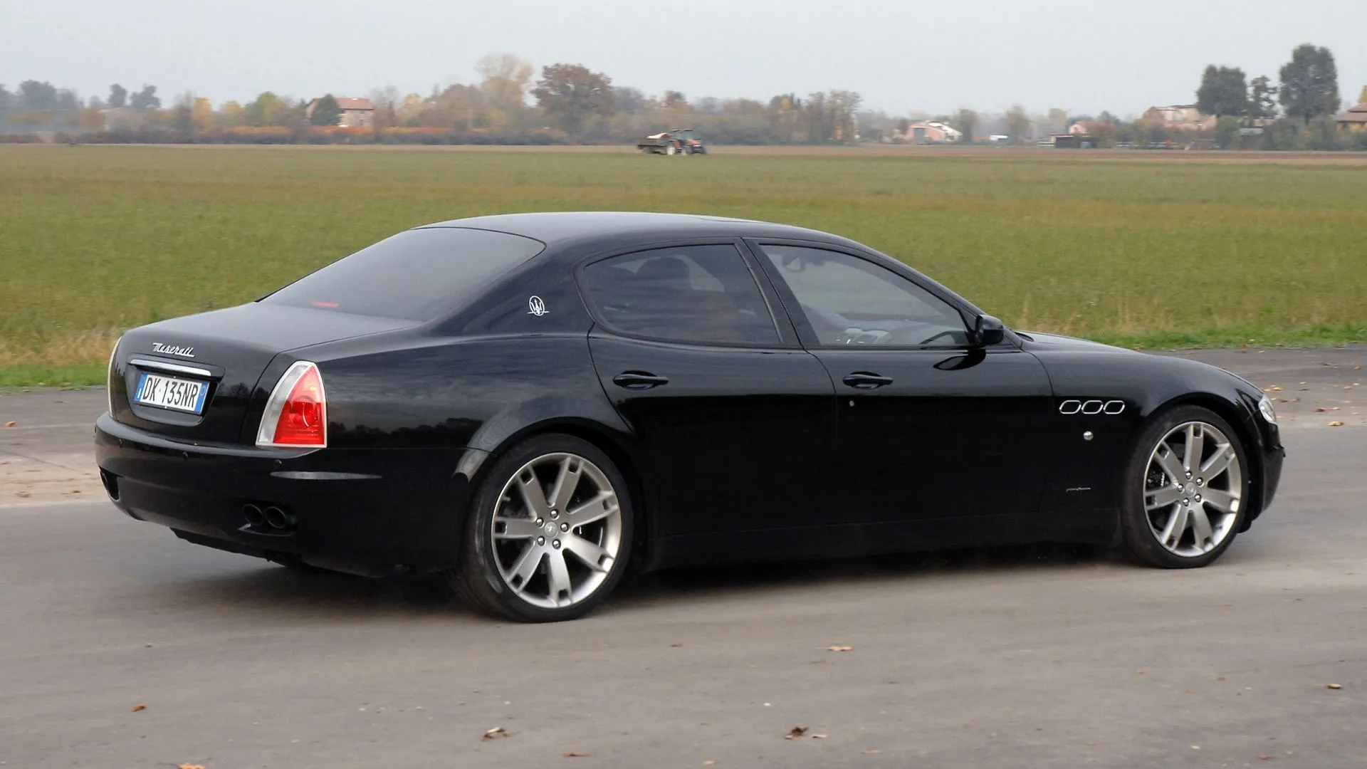 Góc sau 3/4 của Maserati Quattroporte đời 2007 màu đen, ví dụ mẫu còn nhiều trên thị trường xe cũ.