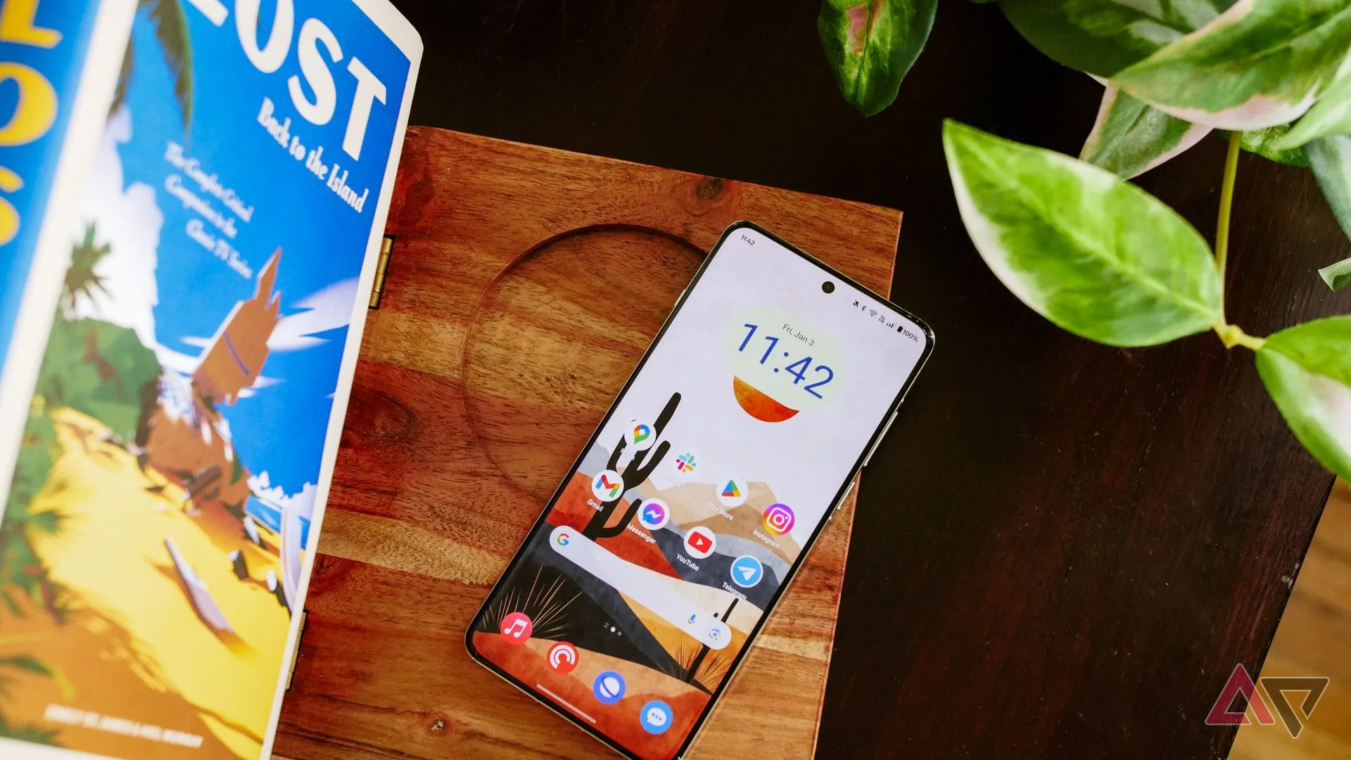 OnePlus 13 đặt trên giá sách với màn hình sáng, tượng trưng cho việc để điện thoại xa tầm tay.