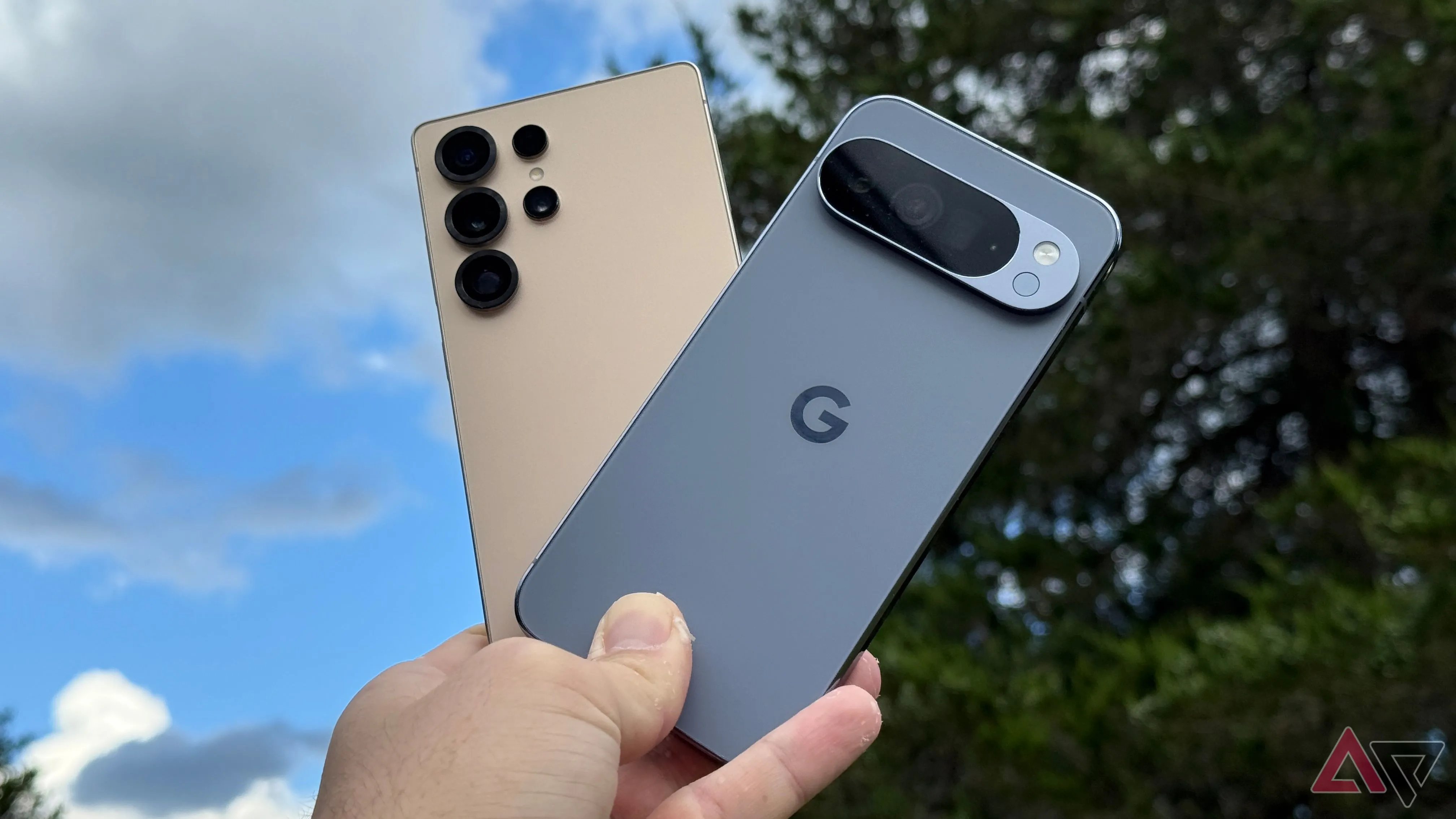 Pixel 10 Pro XL và Galaxy S25 Ultra cầm lên nền trời xanh — so sánh kích thước và thiết kế