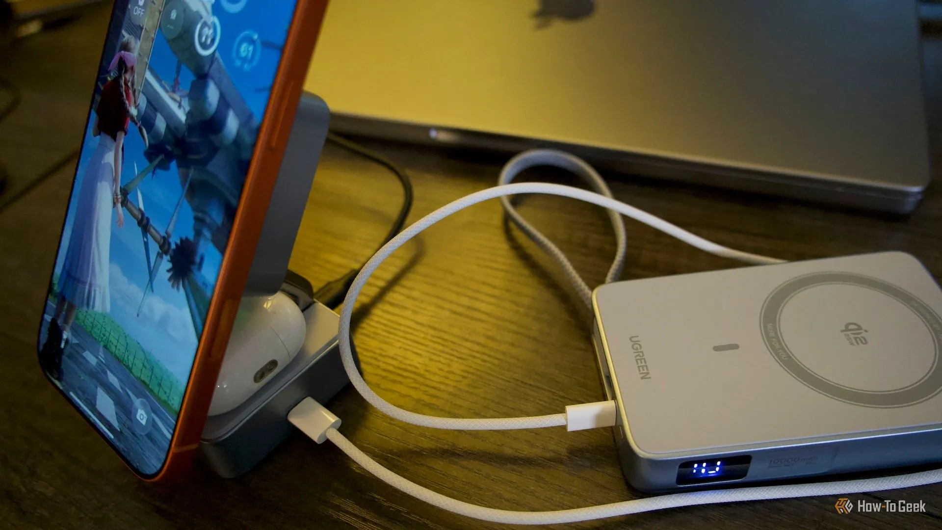 Ugreen MagFlow 2-in-1 đặt trên bàn, kèm iPhone và AirPods, thể hiện cổng USB-C dùng để truyền điện
